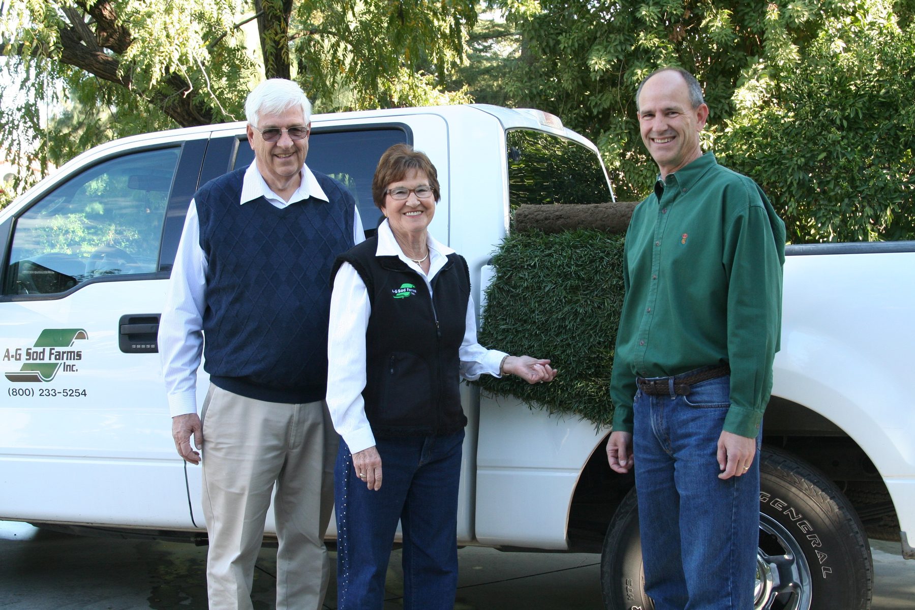 Three generations of the A-G Sod Farms team standing in front of a loaded A-G Sod Farms truck